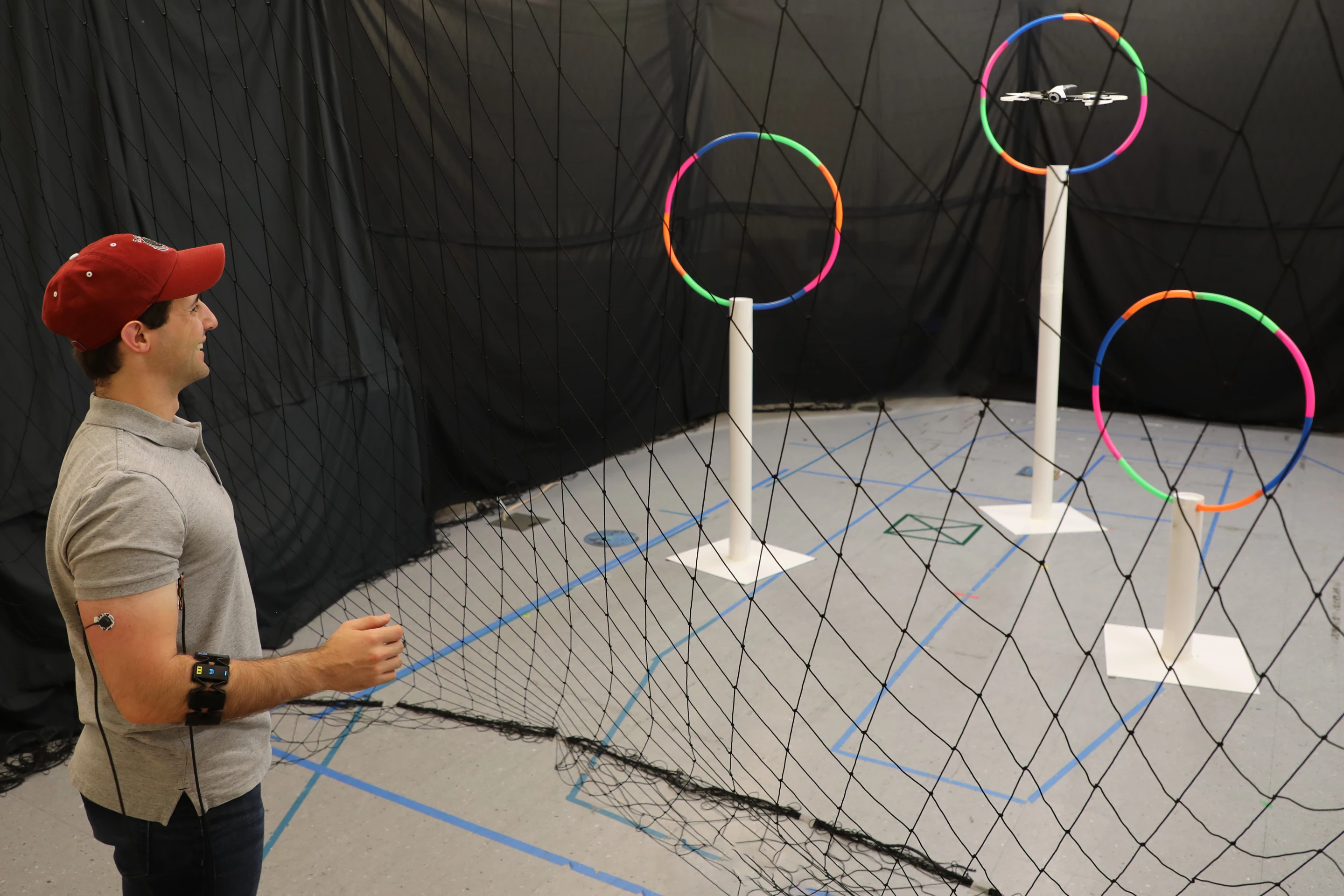 Lead author Joseph DelPreto uses the Conduct-A-Bot system to guide a drone through hoops