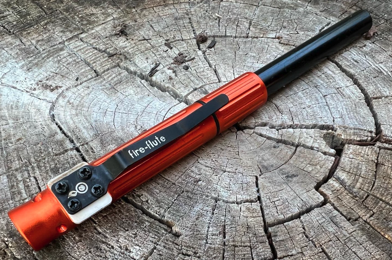 The metal plate behind the screwed-in base of the clip serves as the ferro rod striker
