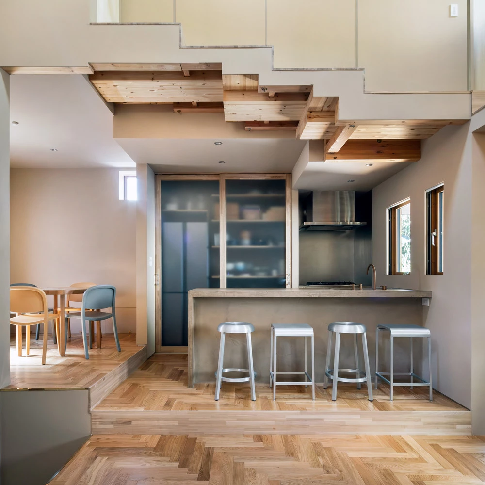 The compact kitchen is elegantly positioned off the stairwell and slightly below the perched dining zone