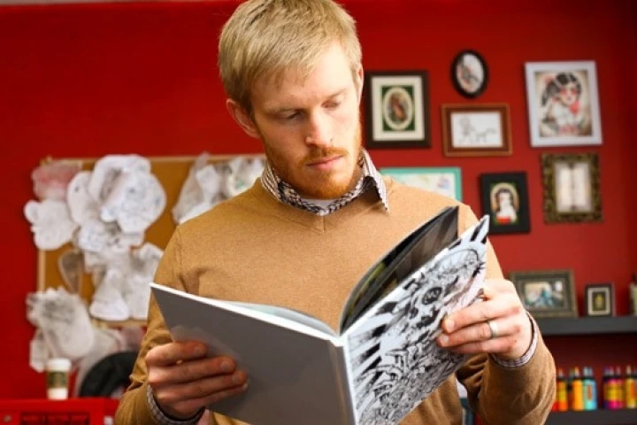 PhD student Alec Falkenham, inventor of the cream, studies a book of tattoos (Photo: Bruce Bottomley photos)