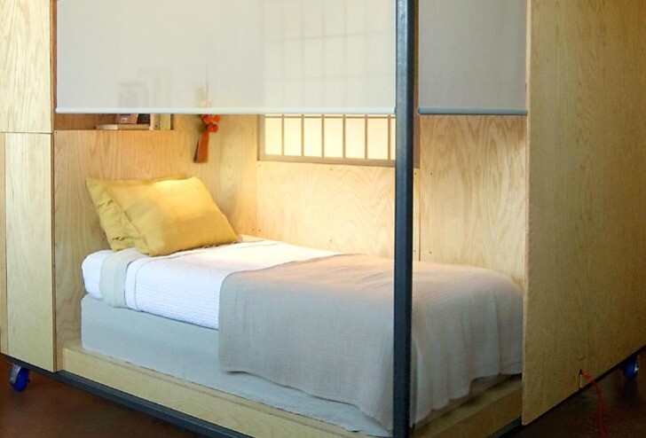 The snug sleeping zone features a single bed and simple shelving for books or other personal belongings