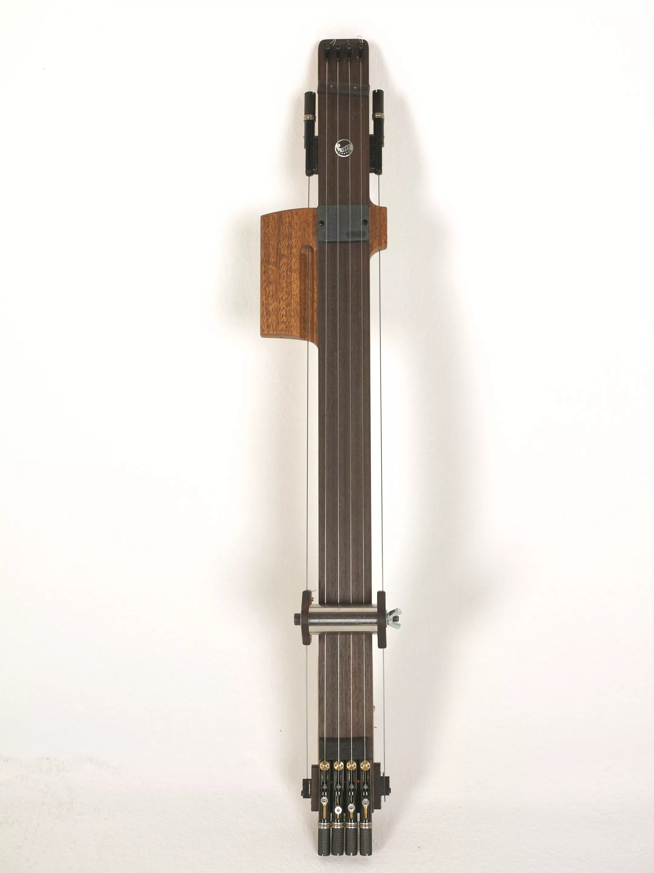 The Reversed Slide Neck replaces the headstock of the prototype with wrap-lock headless tuners, has lost the bass strings of the earlier design, and can now be mounted to a host instrument using magnets
