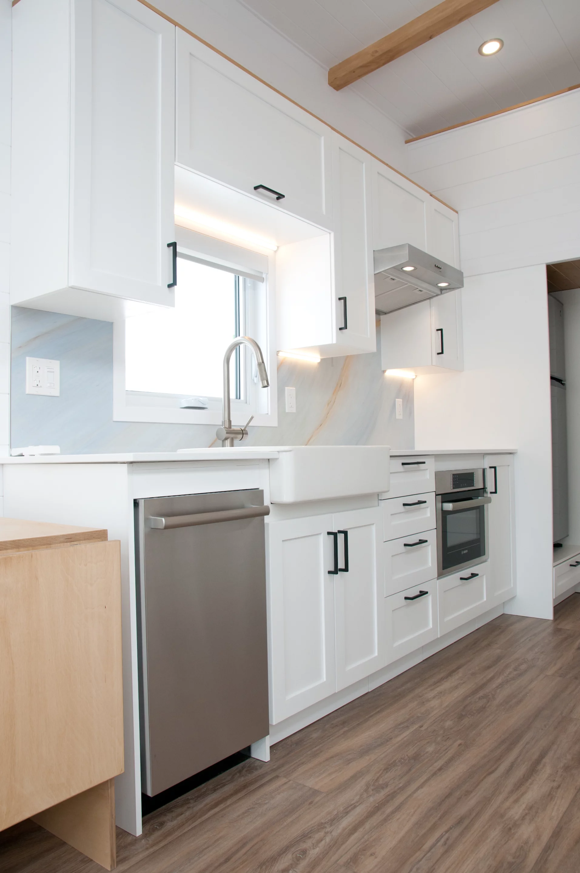 The Magnolia V8's kitchen includes a dishwasher, farmhouse-style sink, microwave oven, and a fridge/freezer