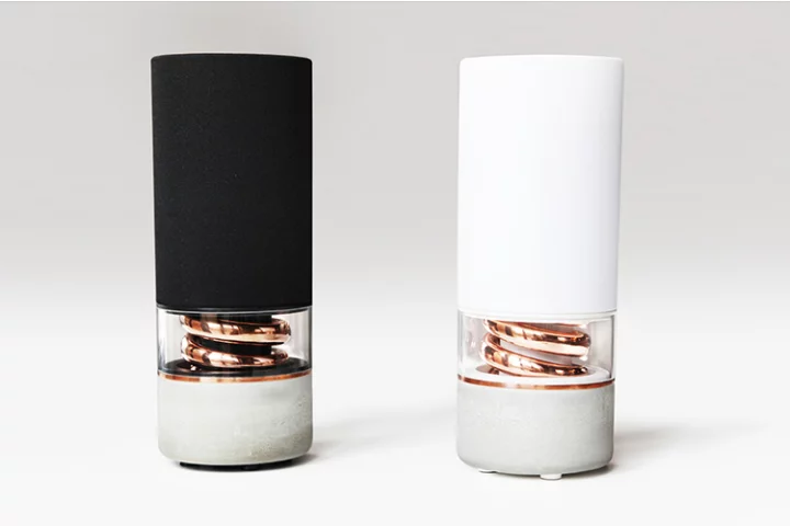 The Pavilion Bluetooth speaker features a high density concrete base, a copper spiral bass port and an American white oak top with indented touch-enabled control buttons