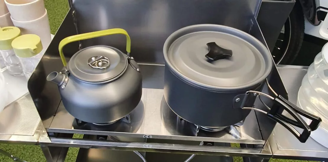 Preparing dinner on the portable kitchen, available optionally for the Mody trailer lineup