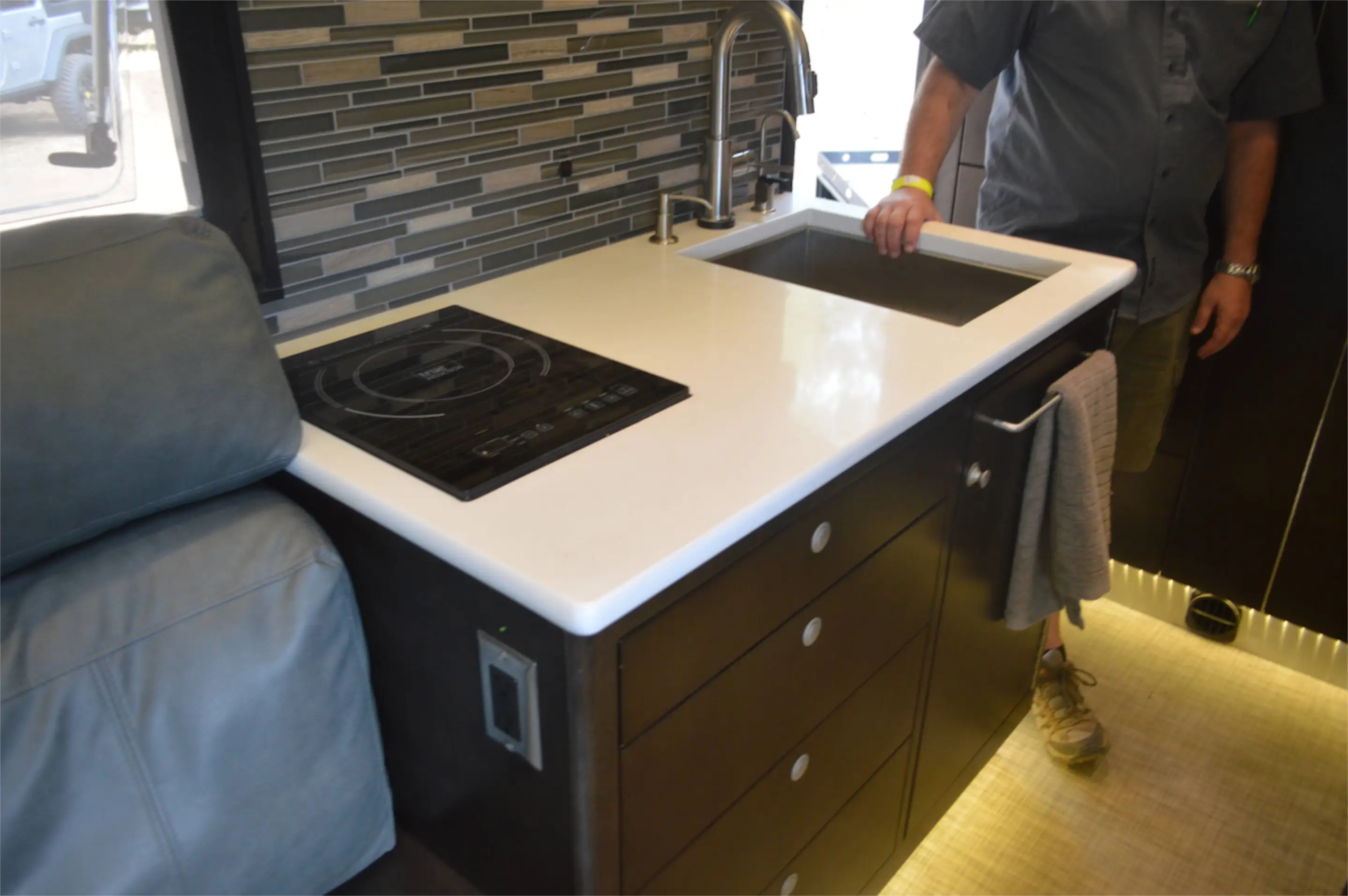 The indoor kitchen area includes a cooktop, sink and a number of drawers
