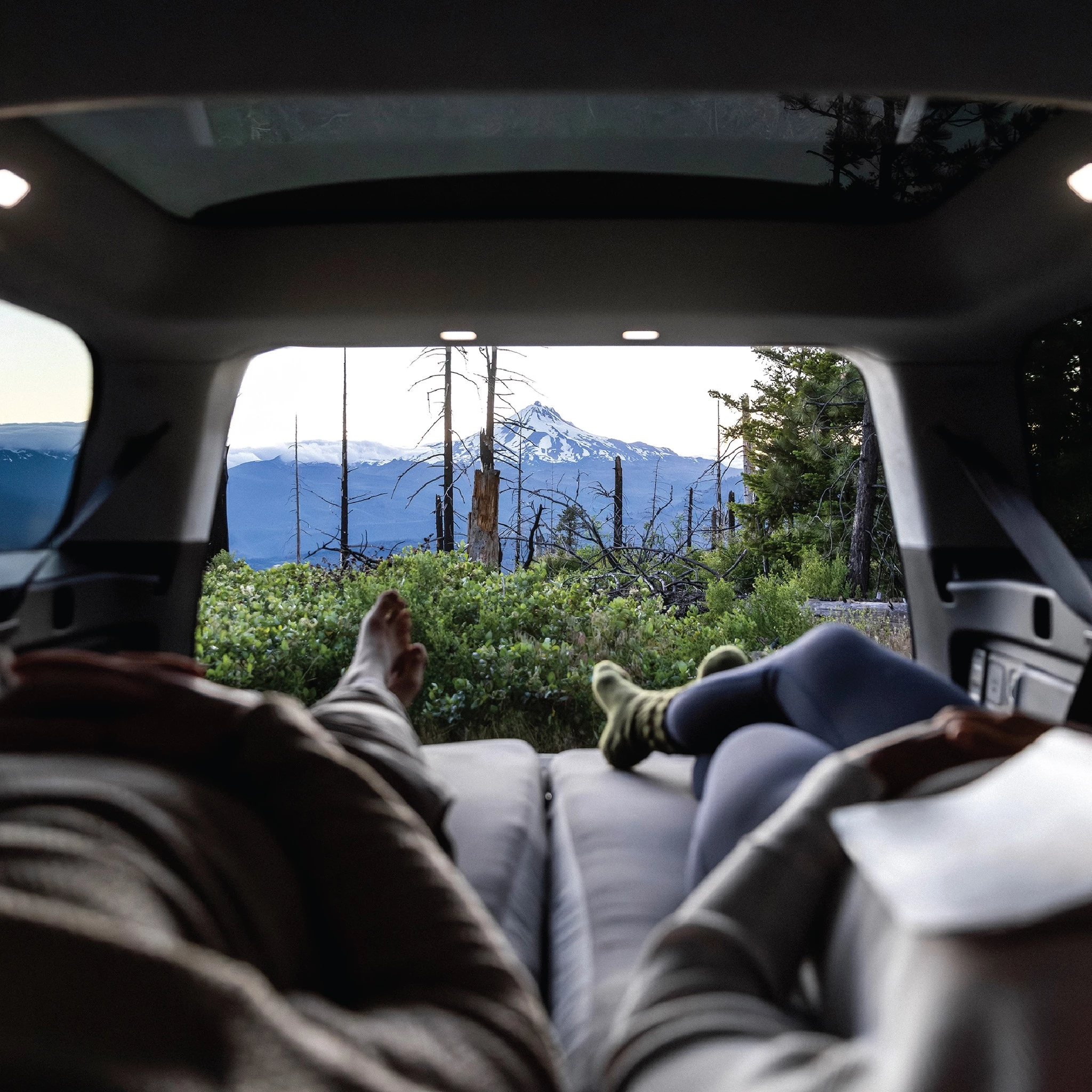 The Rivian R1S isn't quite as spacious as a high-roof camper van, but flip the tailgate and you can still enjoy gorgeous views from the comfort of bed