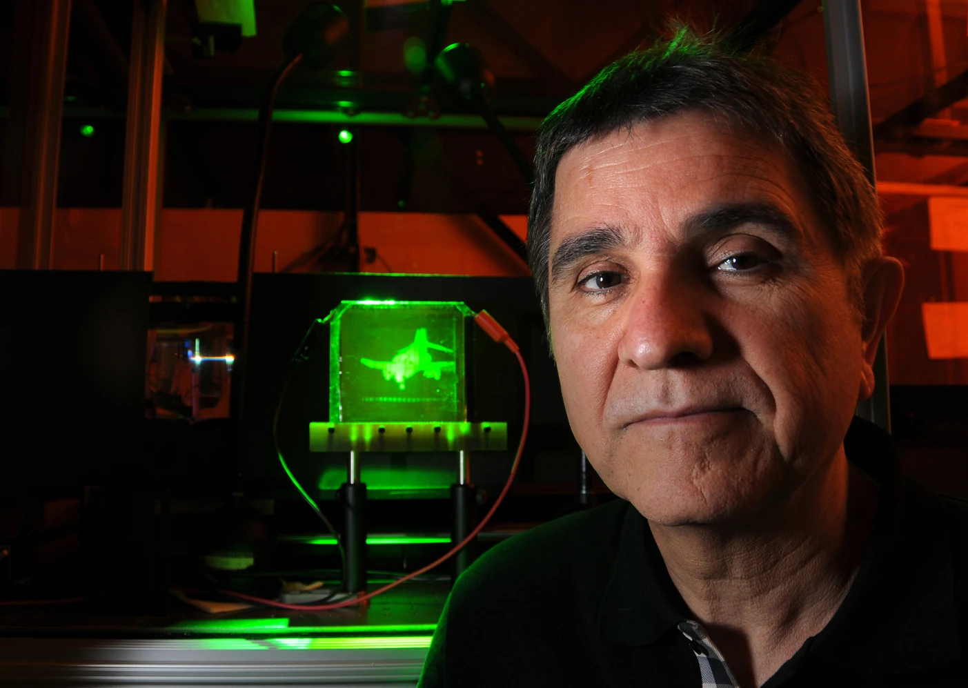 Project leader Nasser Peyghambarian with a refreshable, holographic image of an F-4 Phantom jet (Photo: University of Arizona)