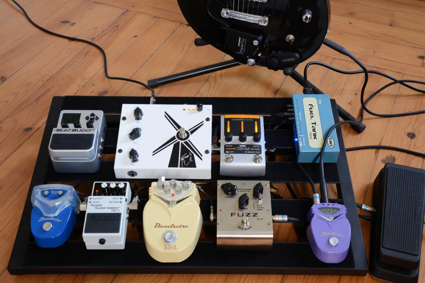 The Trym tremolo pedal placed on a pedal board, controlled by the Aero mounted on a guitar