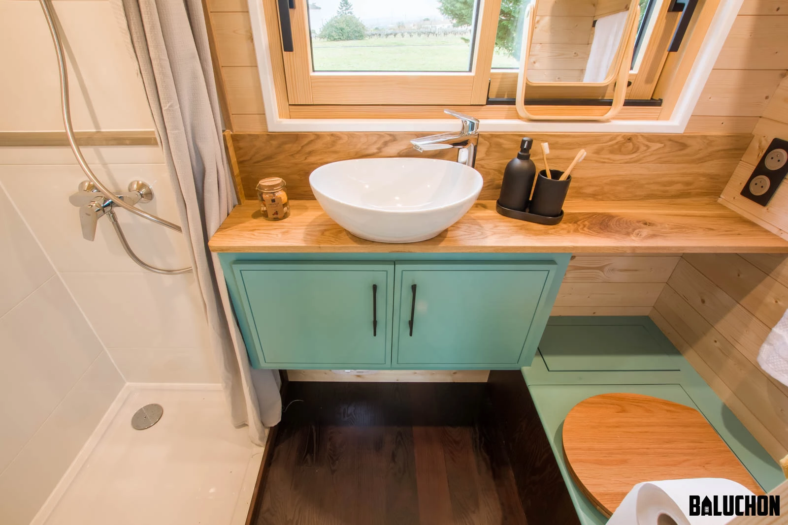 The Tiny house Kalzennig's bathroom includes a shower, sink, and toilet