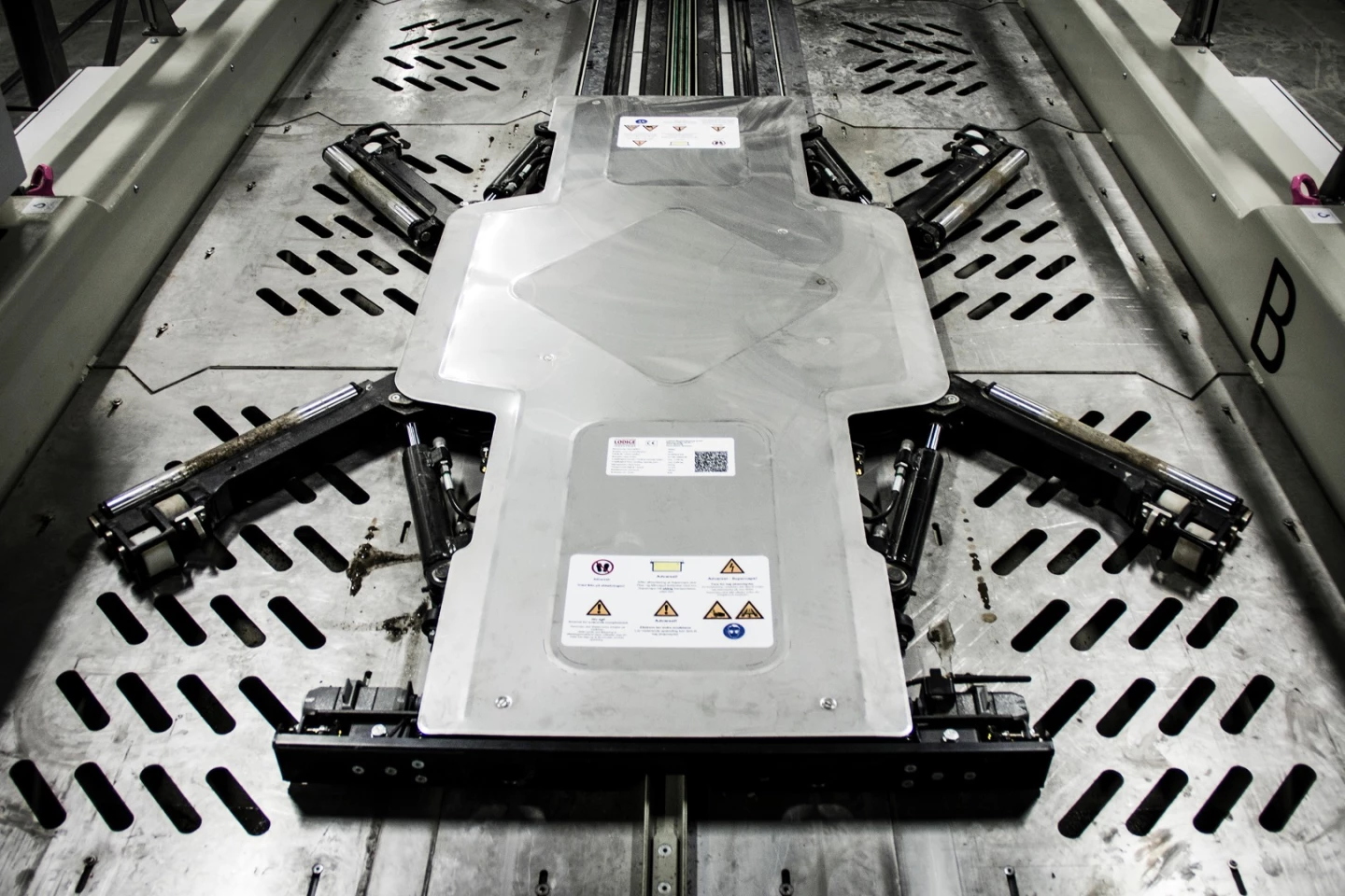 Lödige's technology has a low profile and positions itself below a car before extending its arms to the vehicle's wheels in order to pick it up