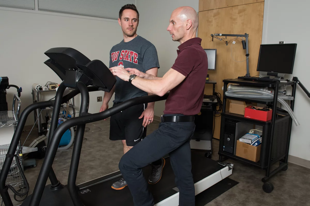 Steven Devor (right) discusses the automated treadmill with doctoral student Rich LaFountain (Photo: Jo McCulty/The Ohio State University)