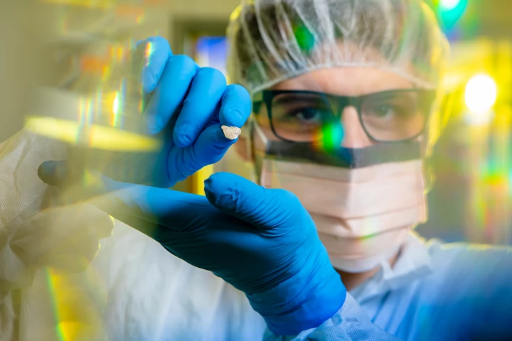 University of Buffalo researcher Flavio Augusto da Silva Coelho holds up an ancient dog bone fragment