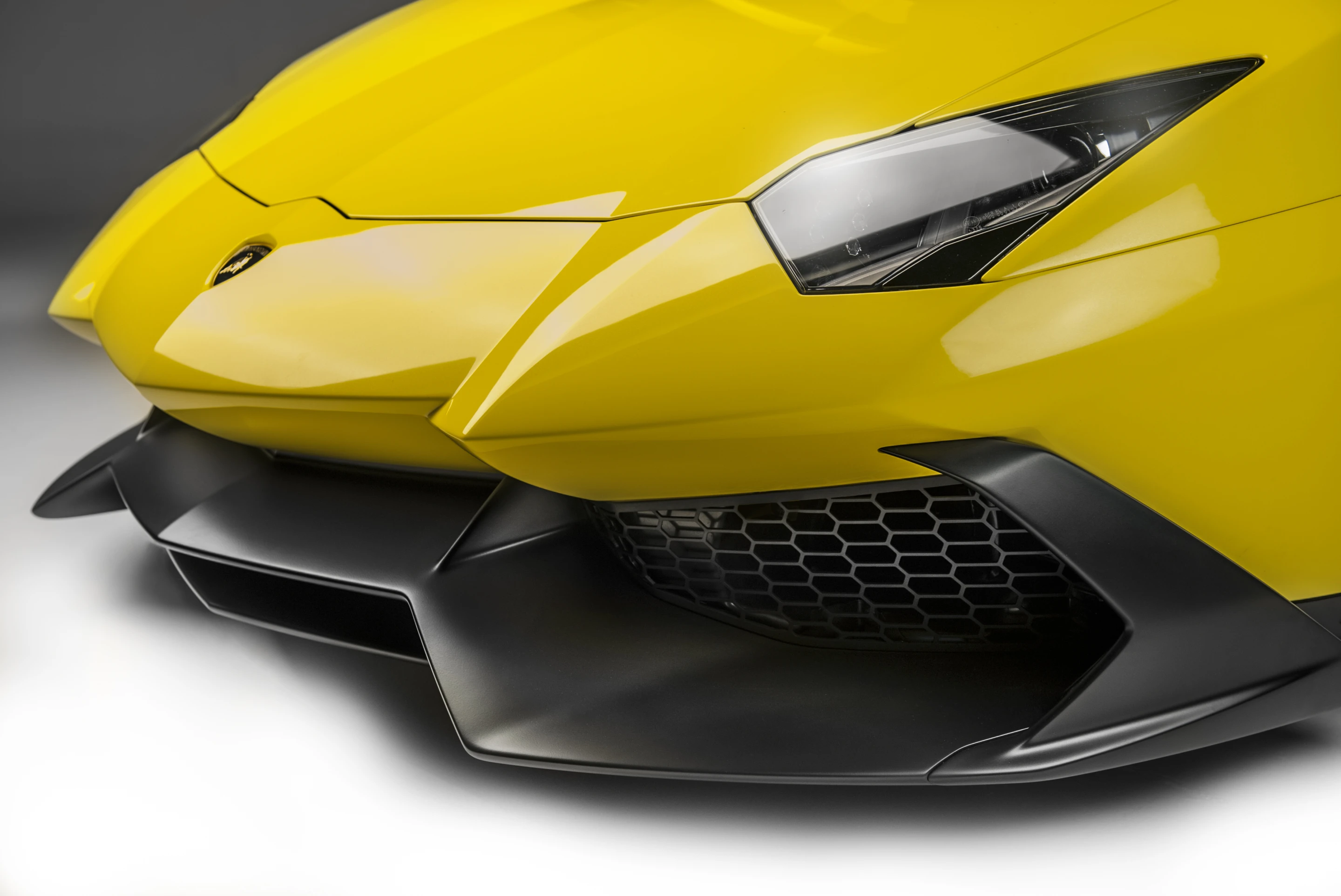Aventador's front air intakes and aero-splitter have been enlarged and extended, with new small winglets added to the sides