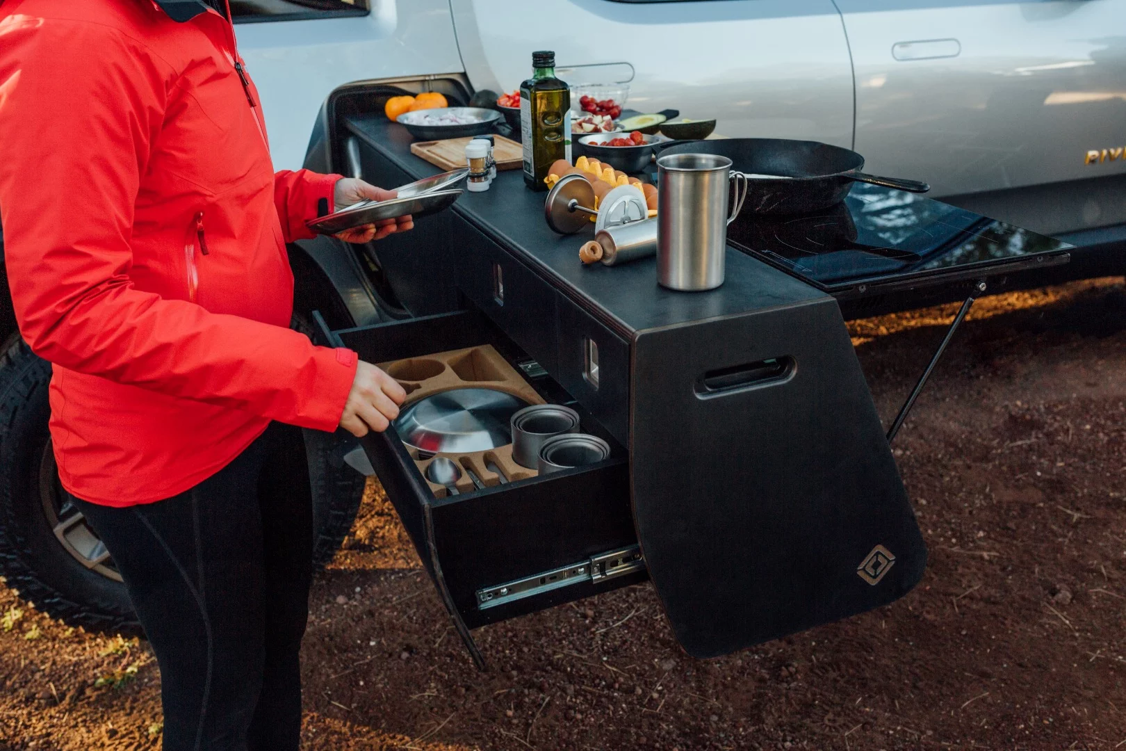 The kitchen includes a storage drawer with dish ware/utensil organizer