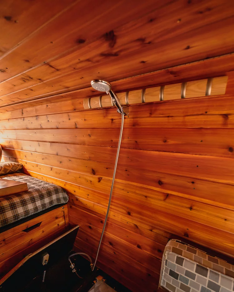 One of the Golden Egg's more interesting tricks — the shower is concealed in the bed steps, popping out for a makeshift shower area and disappearing away to open up space as compared to a full-time bathroom cell