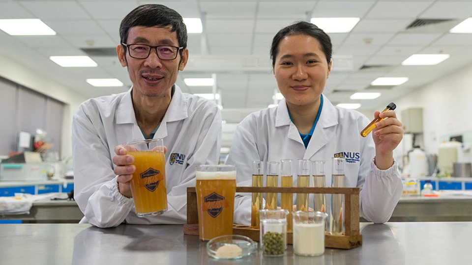 Associate Professor Liu Shao Quan (left) and Chan Mei Zhi Alcine (right), with their bacteria-filled beer