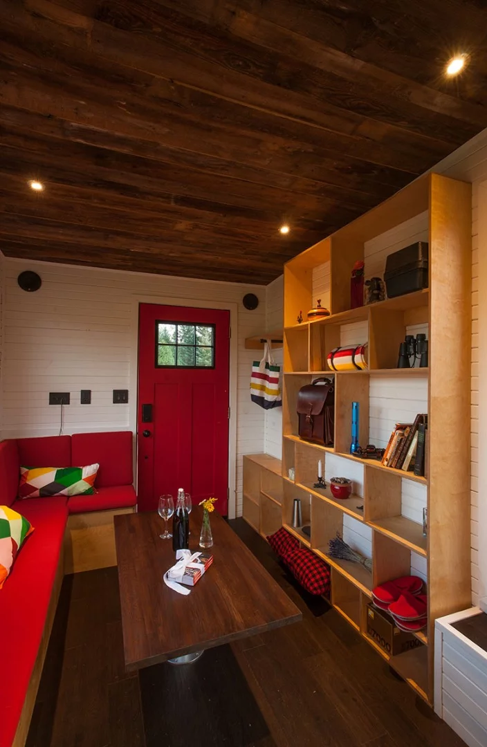 Visitors to the Grenmoxie Tiny House enter the lounge, which features a large couch, movable table, and ample storage space