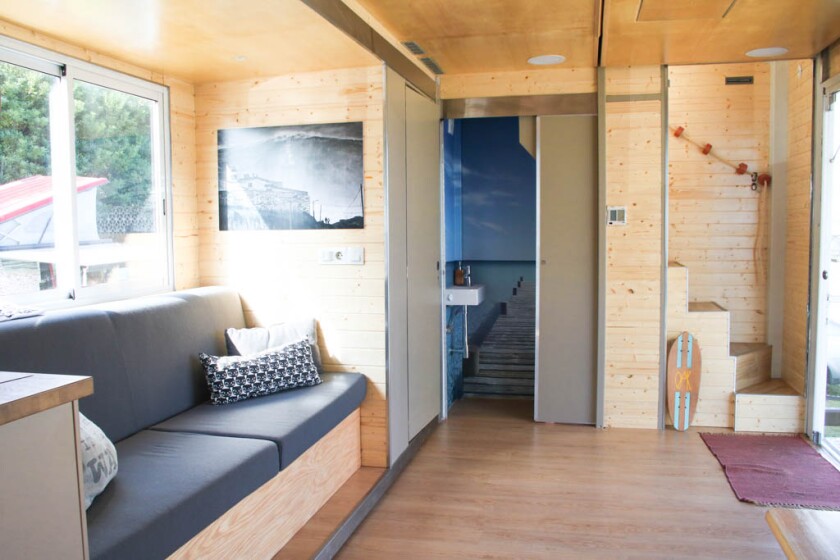 The downstairs of the motorhome-based lodge features an airy living area with seating, kitchen and bathroom