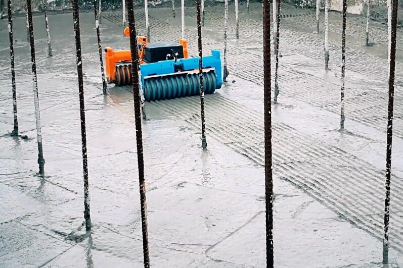 An integrated mechanism keeps the robot's wheels from getting clogged with concrete sludge