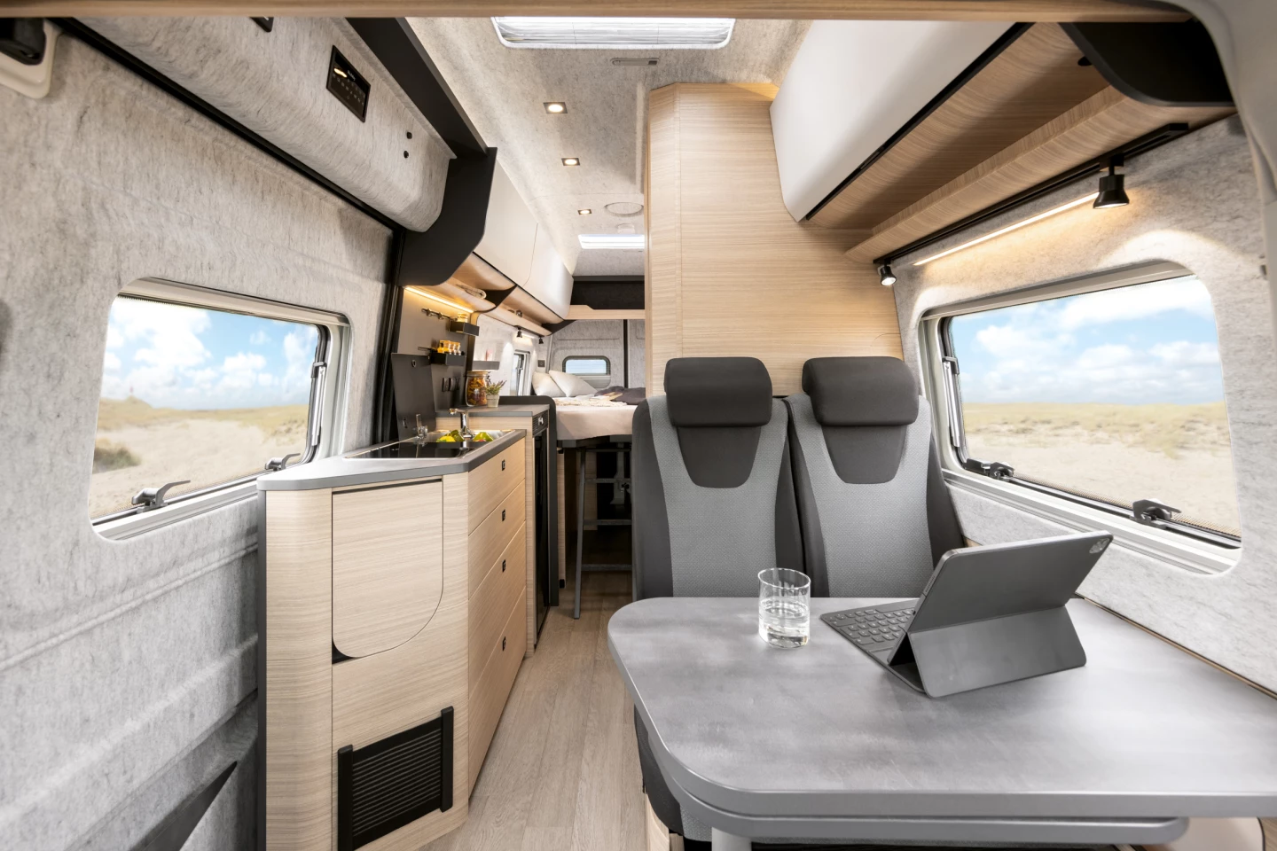 For the single 680 ET Maxia Van floor plan, Hobby uses a combination of soft-touch wall and ceiling trim, dark gray surfaces, and walnut wood walls and furniture