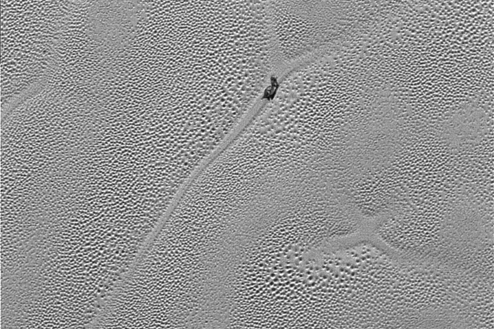 High-resolution image of Sputnik Planum, displaying an x-like artifact in the ice that may in the past have been the joining point between four cell structures