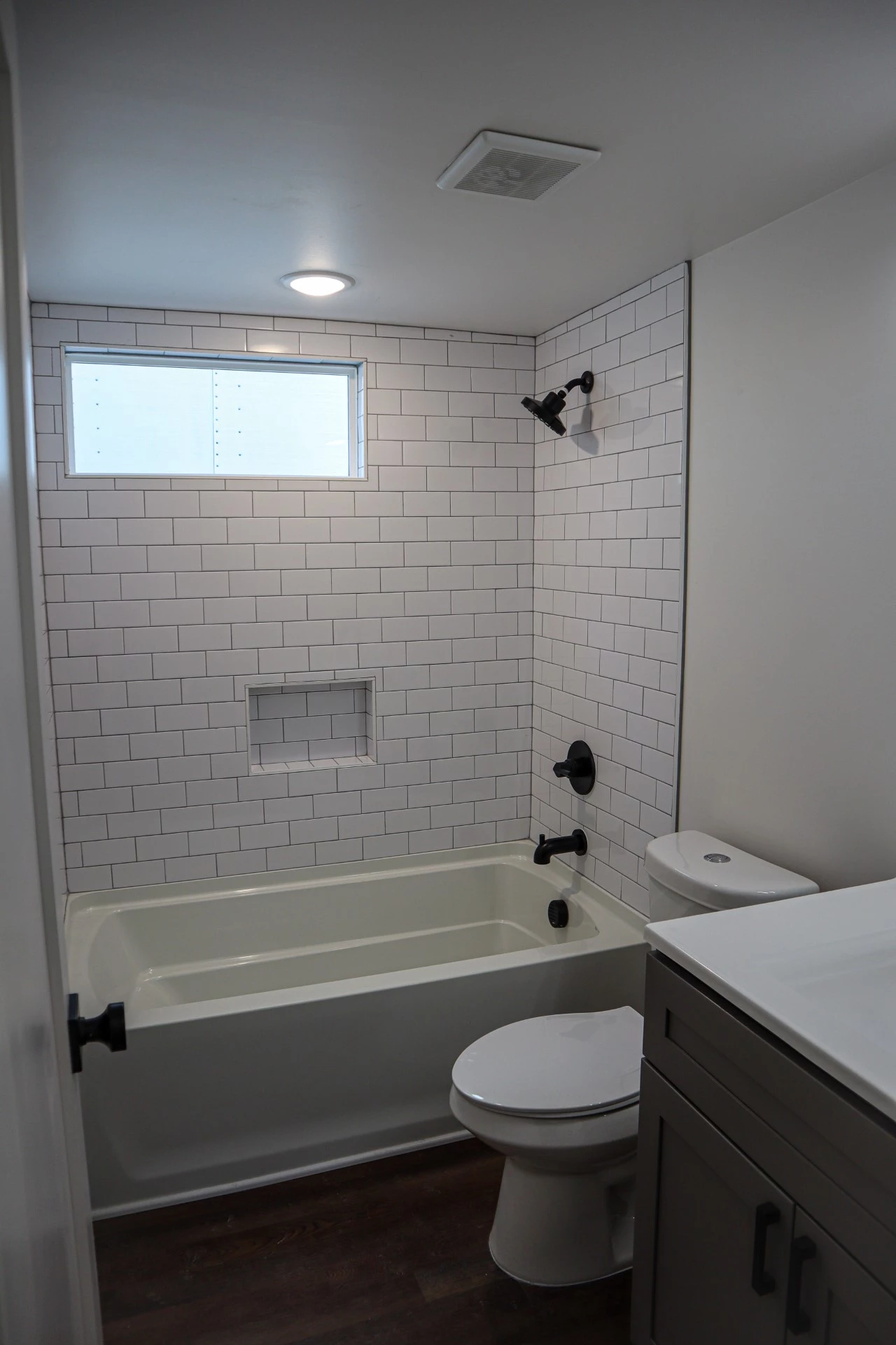 The Dogwood's main bathroom includes a bath/shower, sink, and flushing toilet