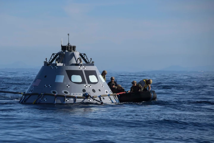 Navy divers from Explosive Ordnance Disposal Mobile Unit (EODMU) 3 attach an inflatable ring to NASA's Orion test vehicle