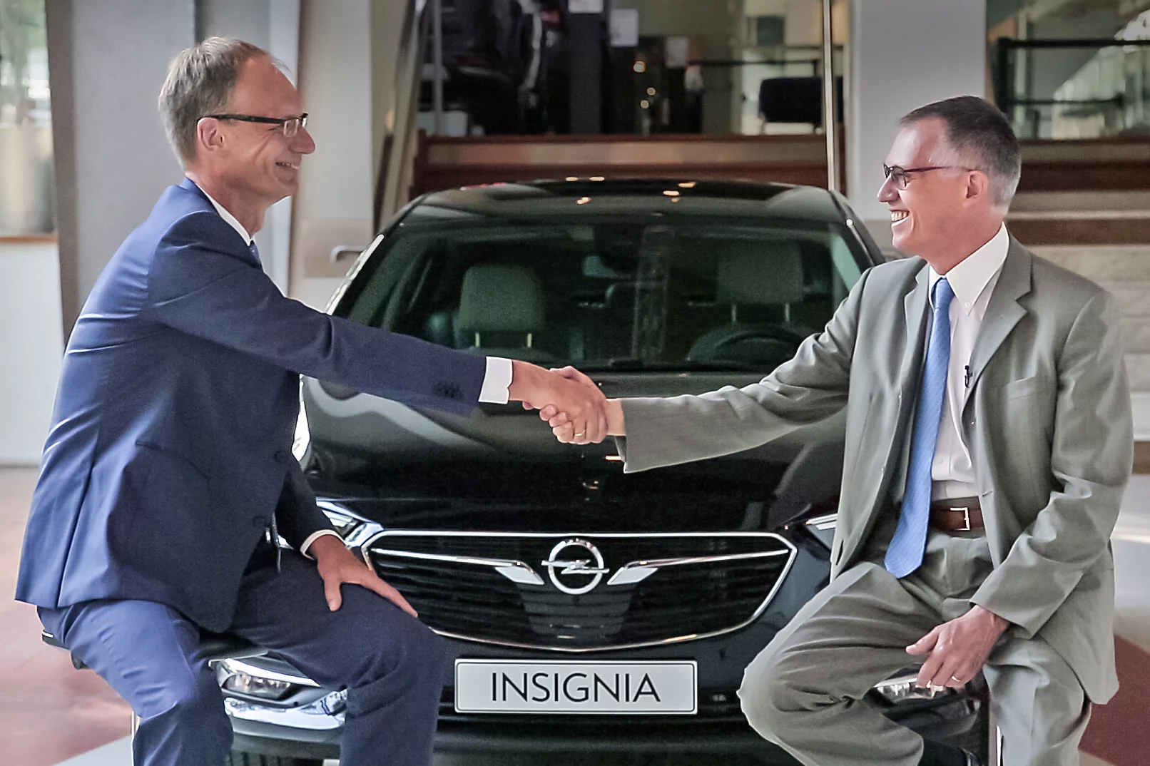 Opel CEO and Chairman of the PSA board in front of a Vauxhall Insignia