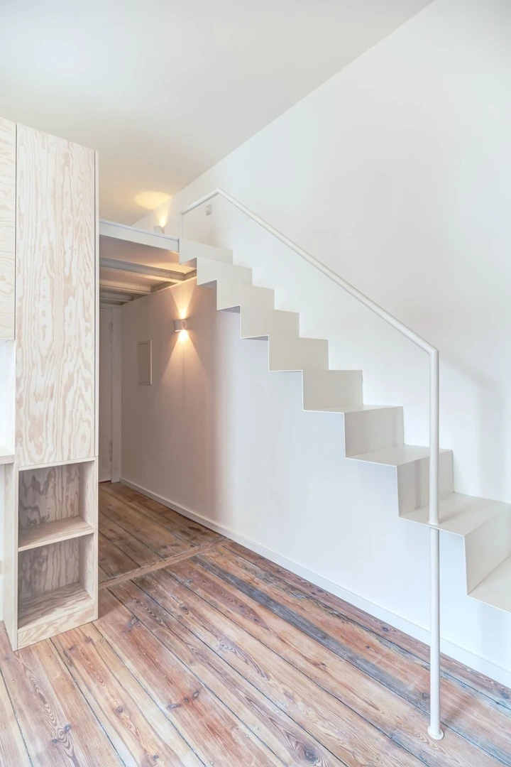 A thin, narrow steel staircase leads to a mezzanine level (Photo: Ringo Paulusch)