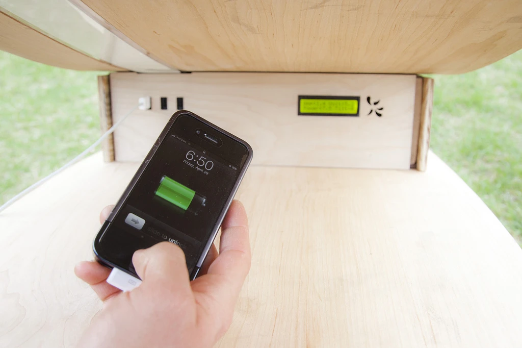 Charging up a mobile device using clean energy provided by the SOFT Rocker's flexible solar panels