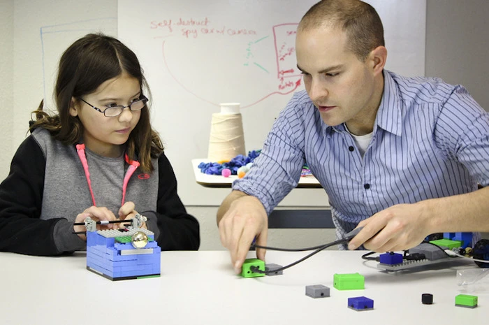 ATOMS Express Toys' Eric Budd building with a member of ATOMS University