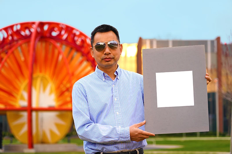 Study author Xiulin Ruan with his lab’s sample of the whitest paint on record