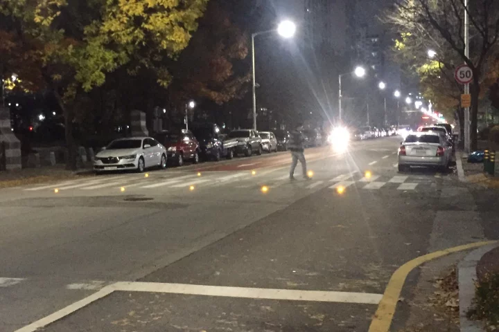 The crosswalk features warning LEDs embedded in the road