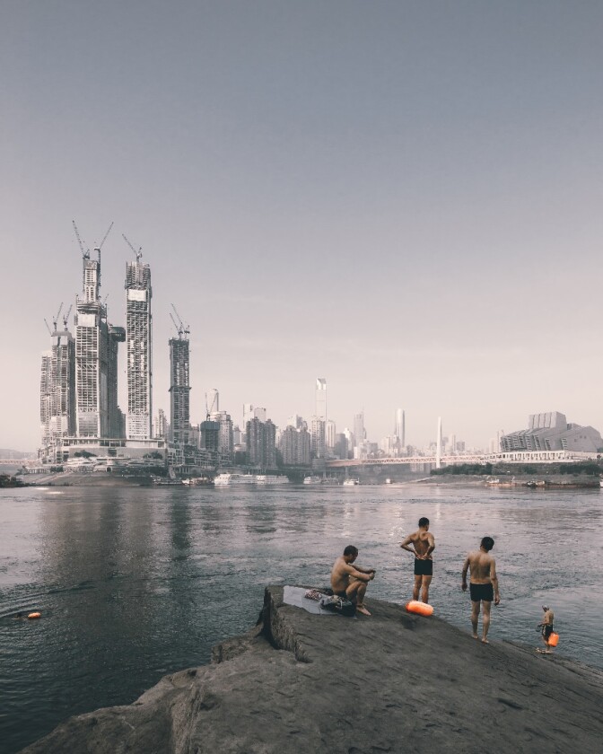 Zhu Wenqiao from China took this image of swimmers on the riverside opposite the construction of Raffles City Chongqing, China built by Safdie Architects. It was entered into the Sense of Place category