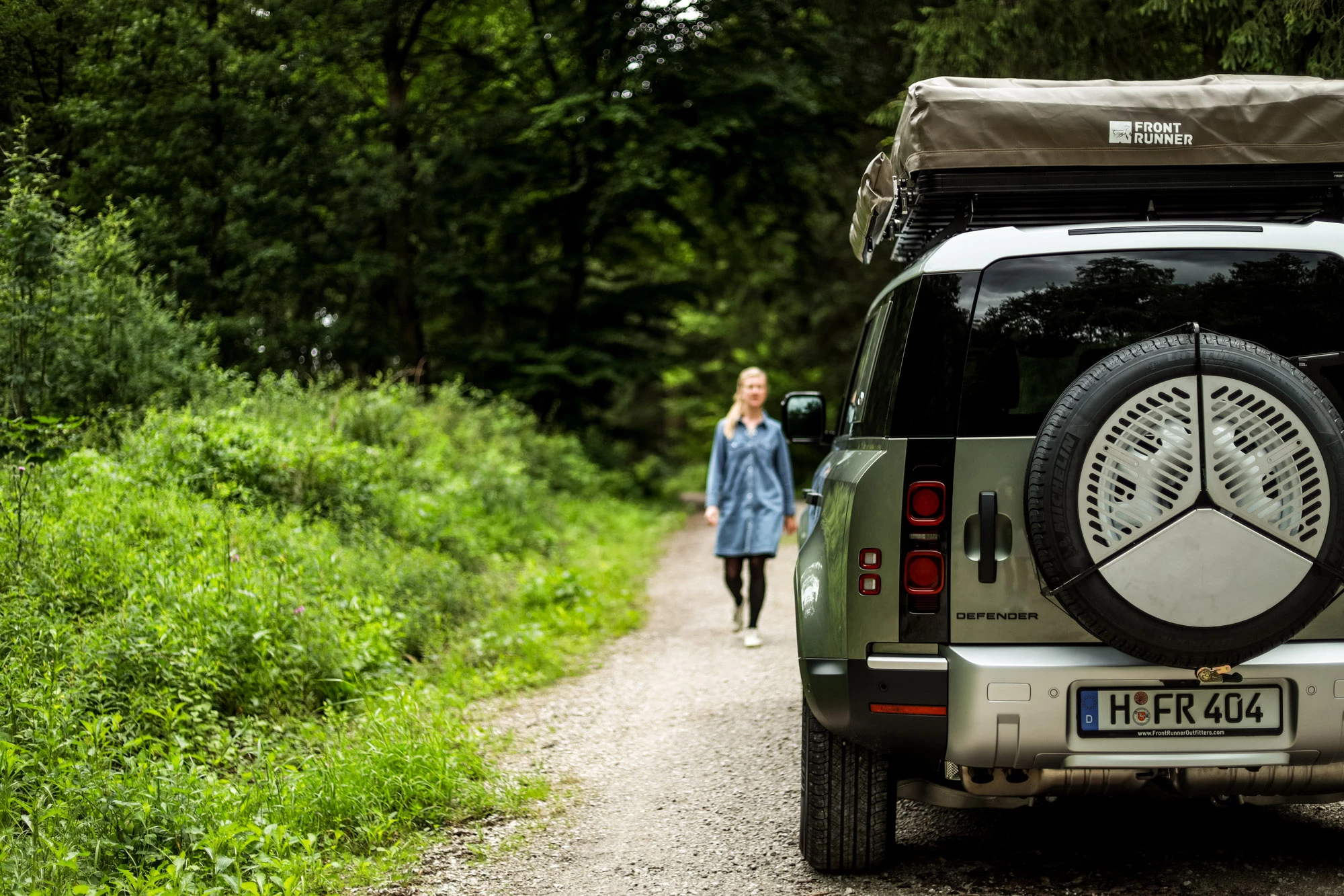 Front Runner sneaks in a shot of its roof-top tent and spare tire-mounted Braai grill