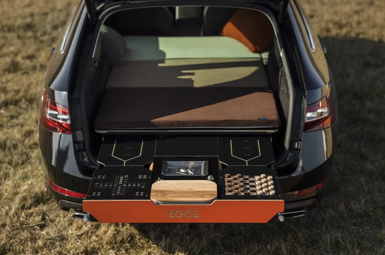 The Egoé Nestboard combines a small kitchen, water storage, a bed for two, and an outdoor work/dining station with integrated game boards