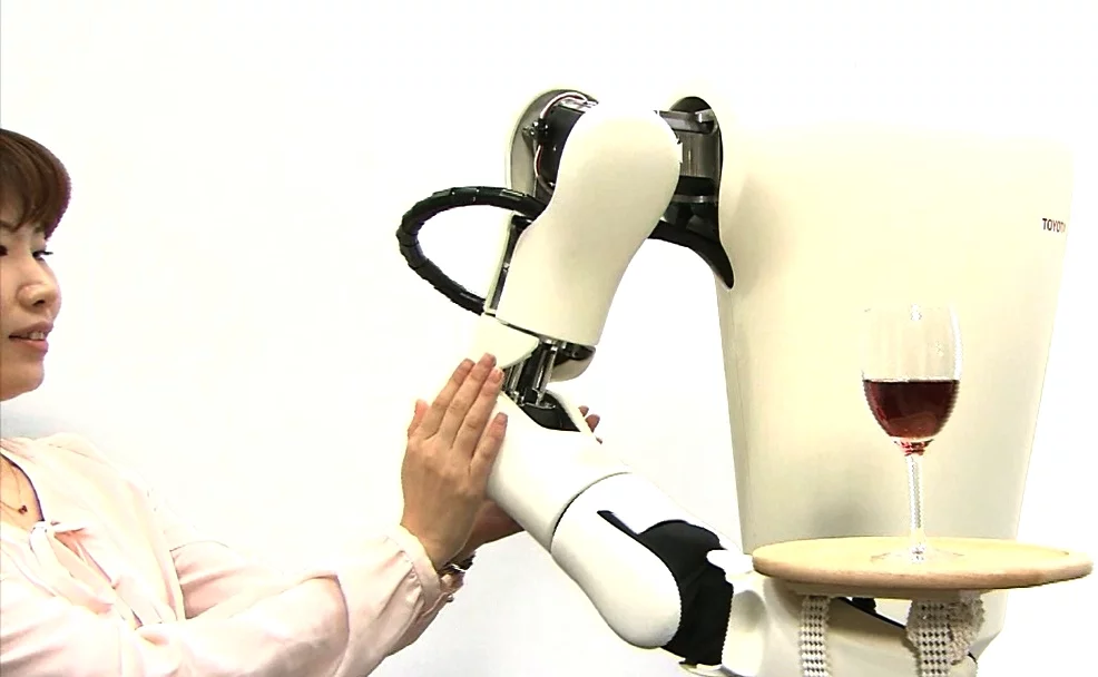 The robot arm maintains its overall position but yields to external forces, allowing it to balance this wineglass