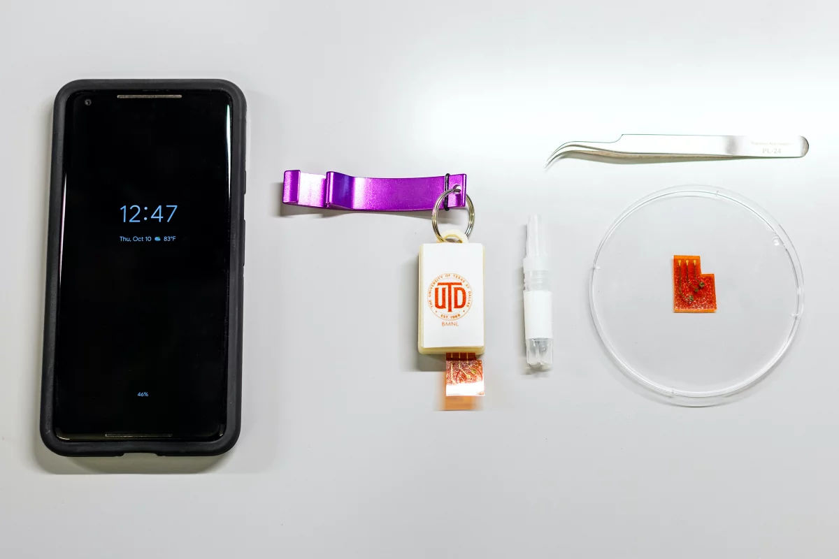 The prototype reader device (center) works in conjunction with a smartphone