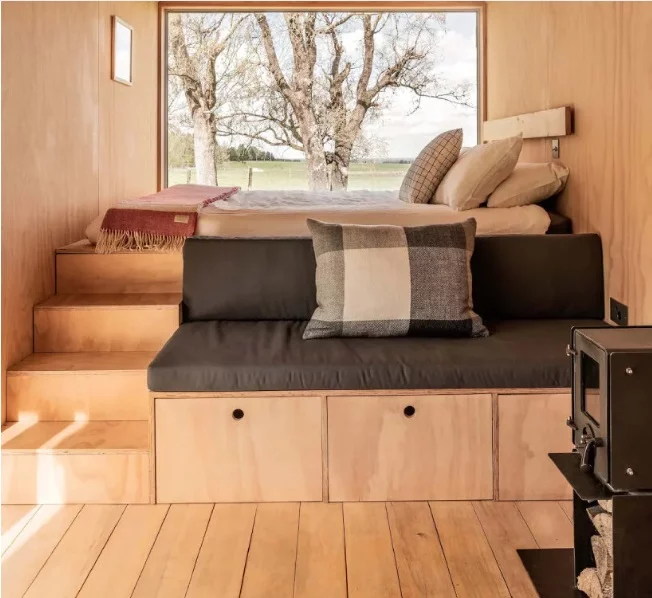 A sofa and storage area are integrated into the bed structure