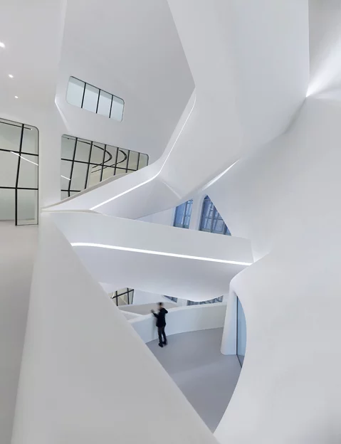 Chaotic yet fluid bleached white acrylic branches and supporting features populate the interior, alongside juxtaposed design touches like unfinished concrete and stainless steel (Photo: Virgile Simon Bertrand)