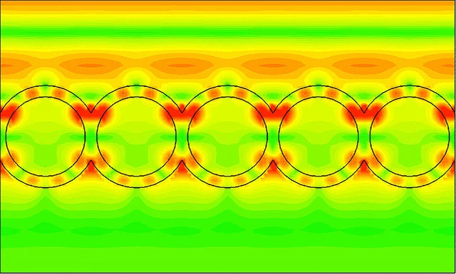 This image from a computer simulation shows how waves of light (in red/orange, traveling from the top of image to the bottom) strike a layer of nanoshells and how the light resonates within the shell structure (in red)