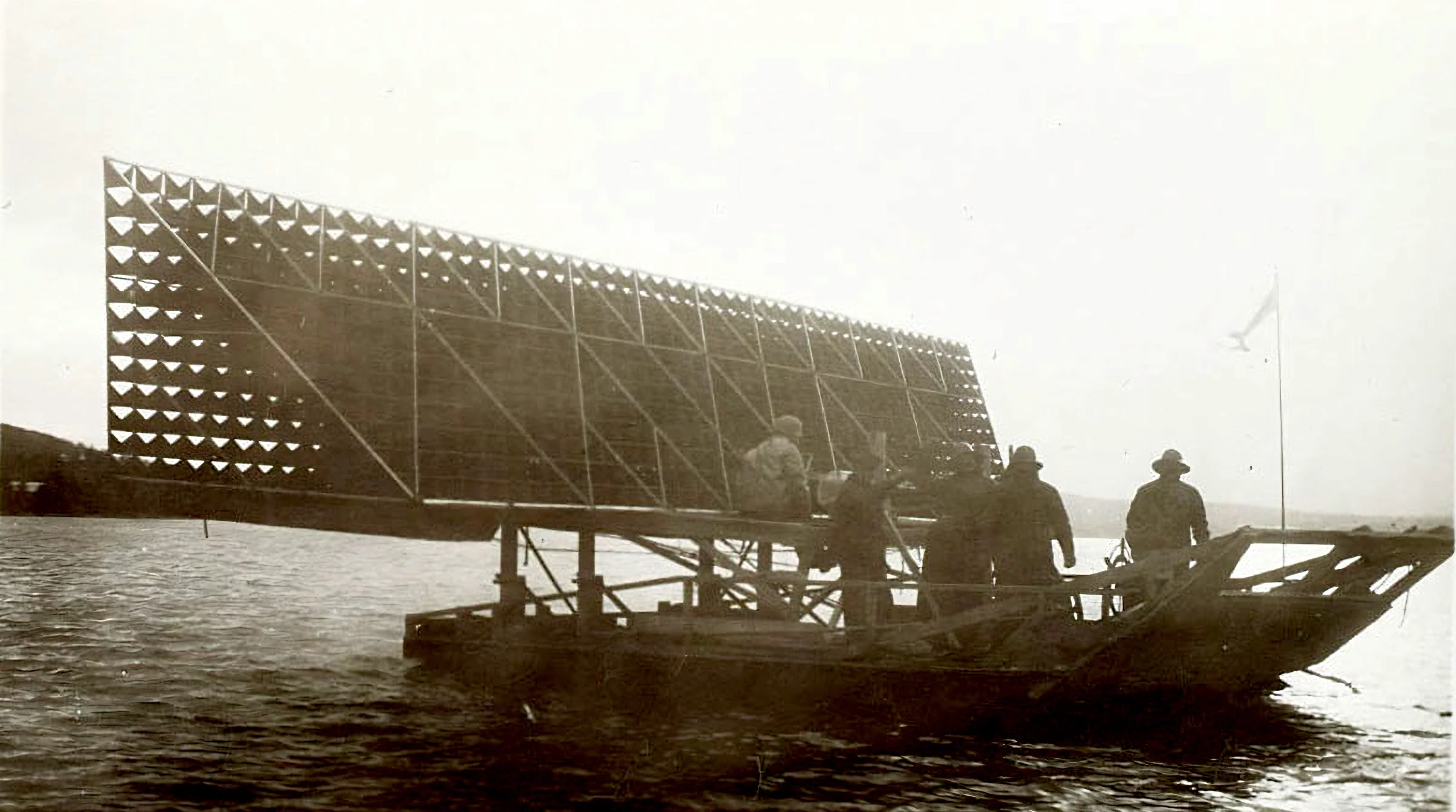 That's Bell's Ugly Duckling air boat being used as a tender vessel during some AEA flight testing in 1907. That's AEA member Lieutenant Thomas Selfridge of the U.S. Army Signals Corps in the light colored oil skins, sitting on the tilting-frame of his experimental Cygnet I. Selfridge was the first military official in history to take flight in a fixed wing aircraft, the first to fly a military aircraft (a dirigible) and a month after that he became the first person to die in an airplane crash.