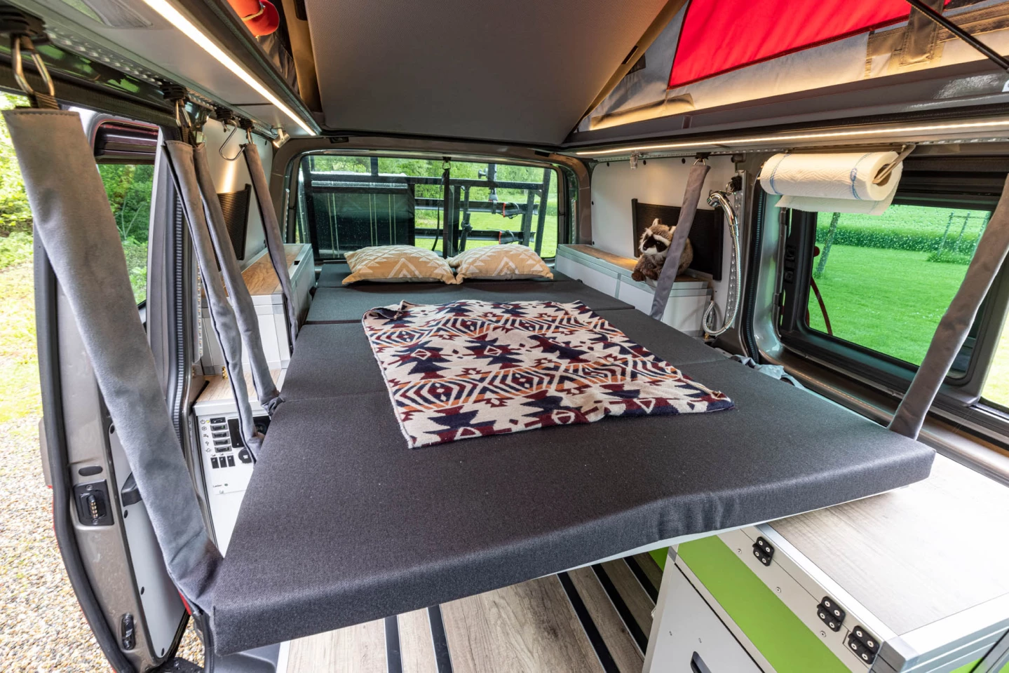 Shown here in an older VW Transporter Tecamp, Terracamper's bed design goes up over top the kitchen and folded rear seats