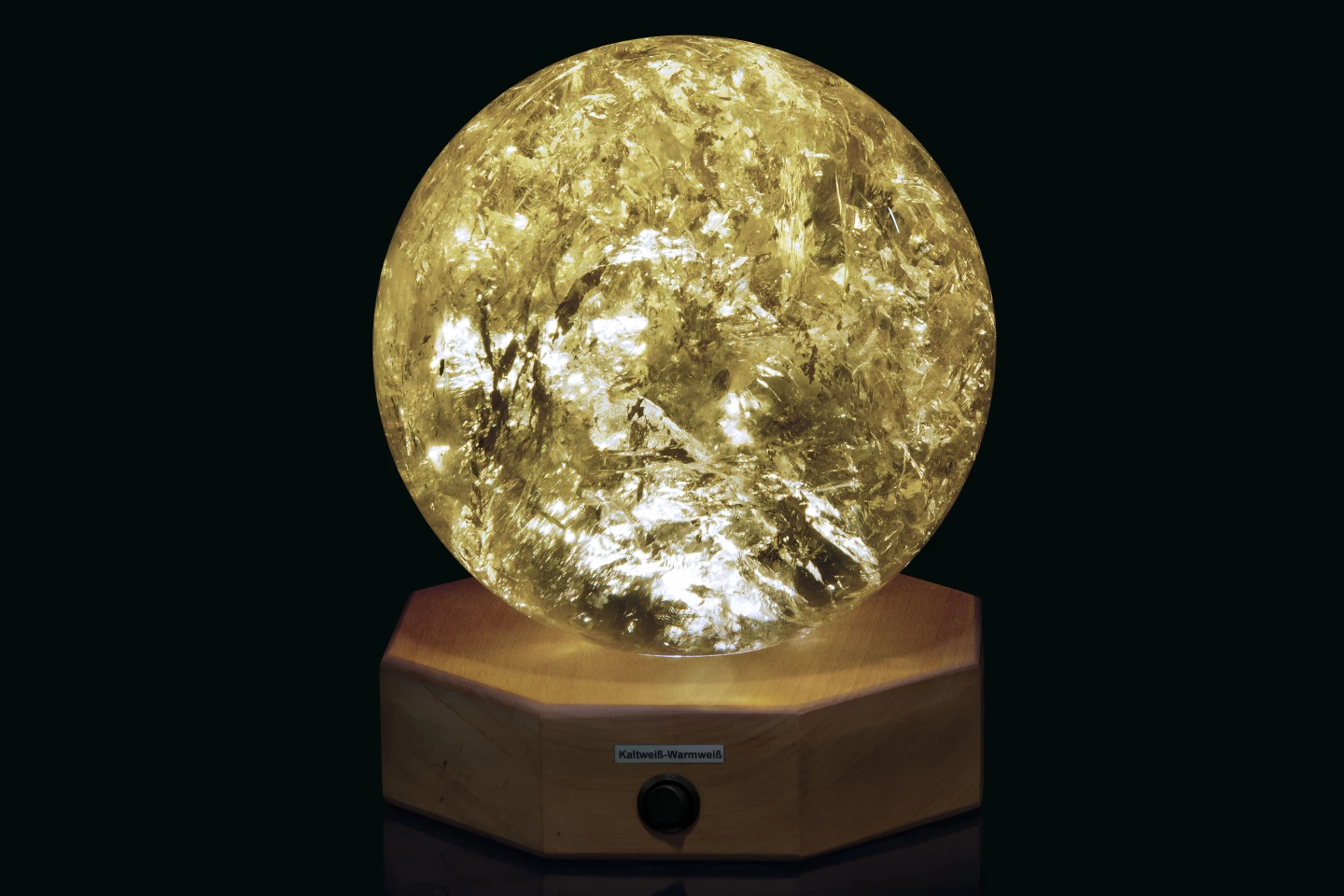 This 81⁄2 inch (21.5 cm) diameter spherical Citrine sample from Brazil has been polished to reveal areas of rainbow iridescence. The specimen is mounted on a wood base with lighting for the specimen from below.