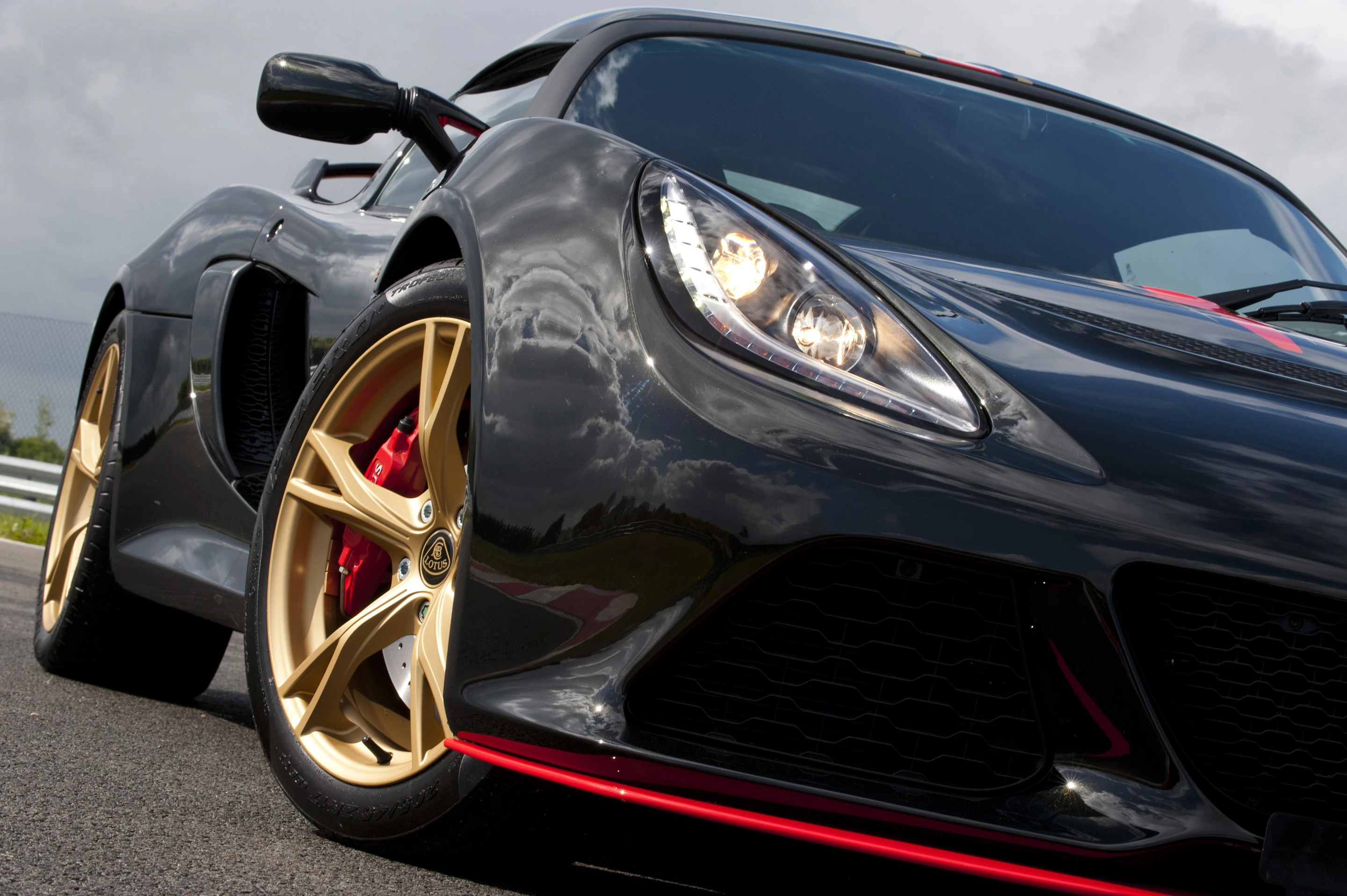 The black and gold styling is accented by red brake calipers, stripes and trim