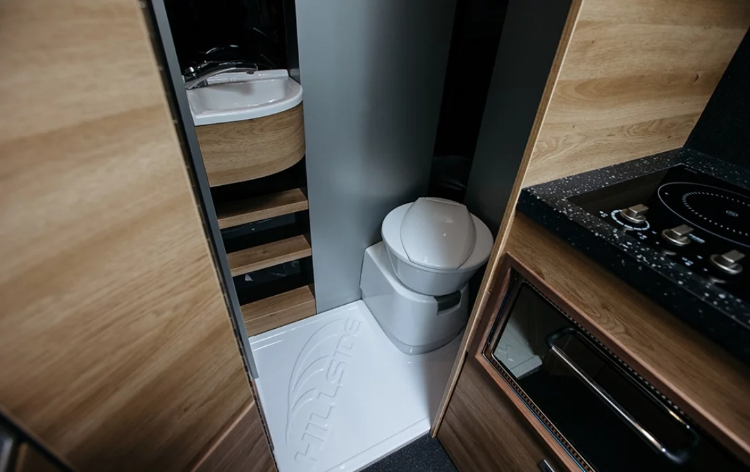 The full width bathroom includes a cassette toilet, vanity sink and separate shower