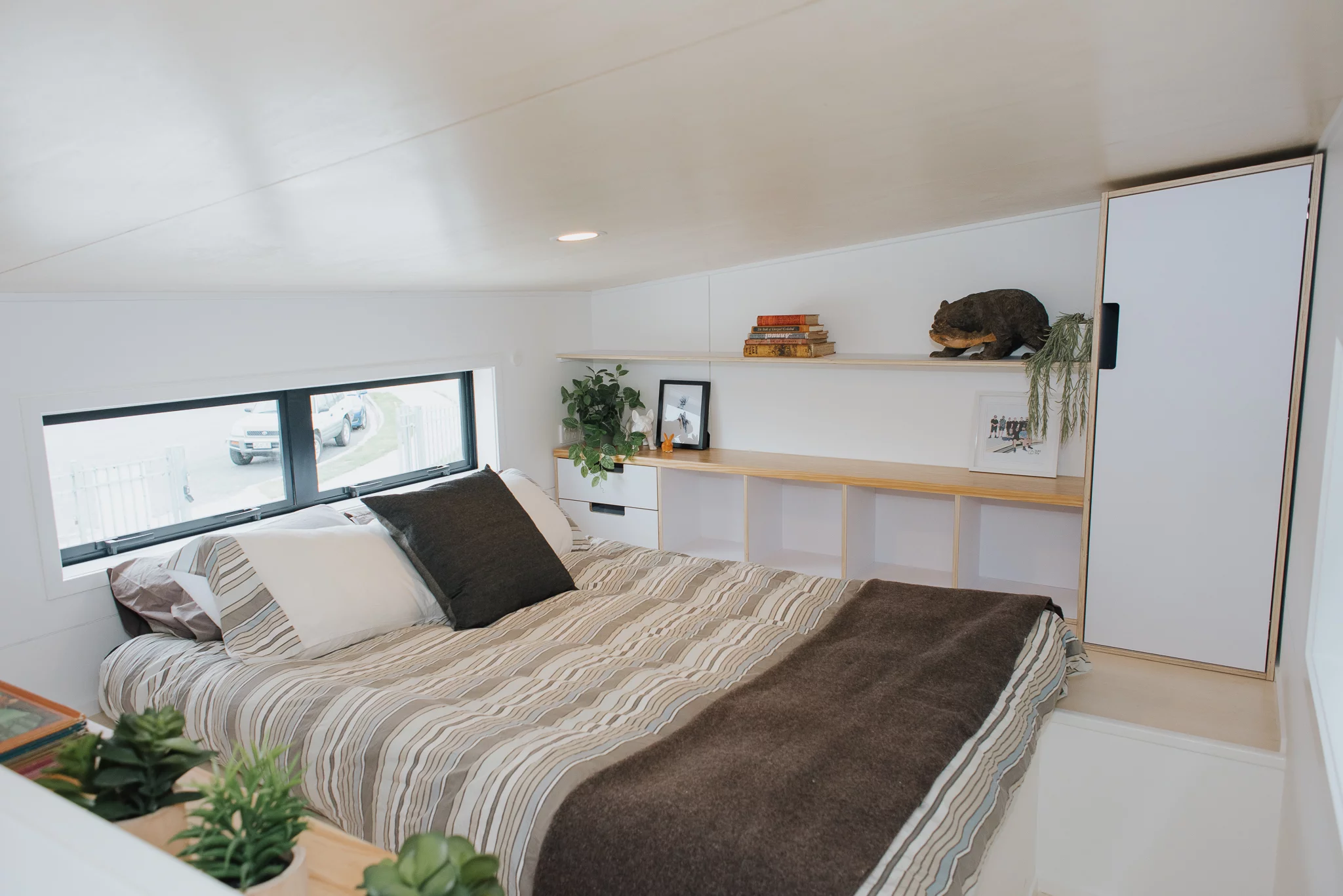 Cyril the Tiny House's bedroom is a typical tiny house-style bedroom with a low ceiling, though it does include a lowered platform standing area to make it easier to get dressed