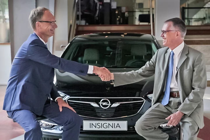 Opel CEO and Chairman of the PSA board in front of a Vauxhall Insignia