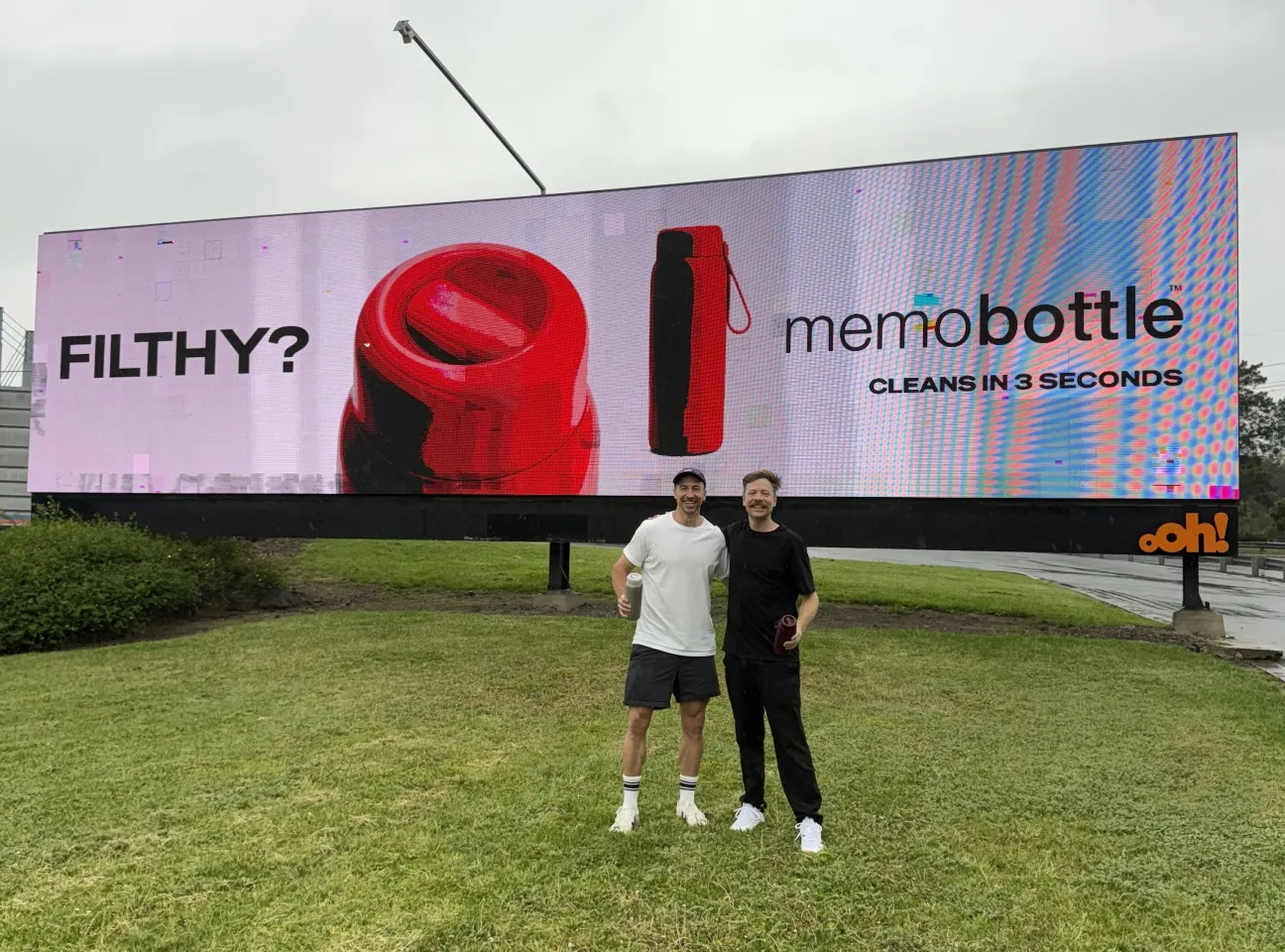 Company founders Jesse Leeworthy and Jonathan Byrt pose for a selfie with the memo Round billboard ad